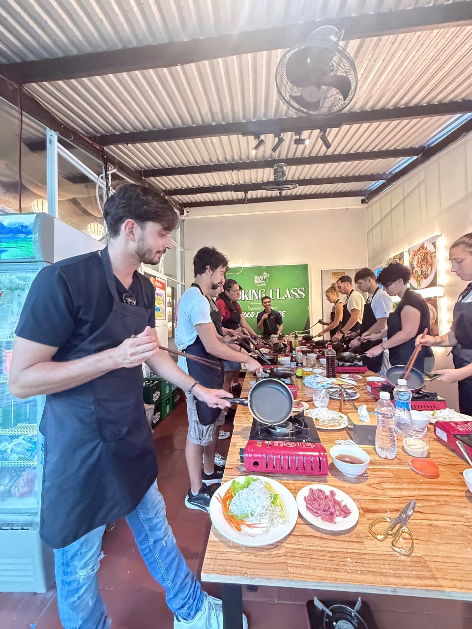 Long montrant un geste de cuisine aux participants